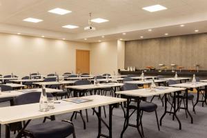 einen Konferenzraum mit Tischen, Stühlen und einer Tafel in der Unterkunft Tryp by Wyndham Istanbul Atasehir in Istanbul