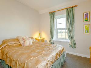 a bedroom with a bed and a window at Jacks Cottage in Tinwell