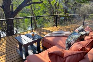 a deck with two couches and a table on it at Bundox Villas in Hoedspruit