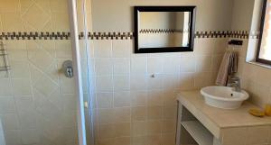 a bathroom with a sink and a shower with a mirror at Fish Eagle Villa in Hoedspruit +10 photos