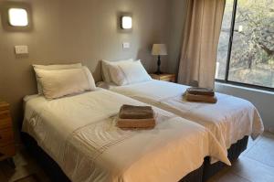 twee bedden naast elkaar in een slaapkamer bij Bundox Villas in Hoedspruit
