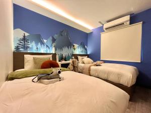 a bedroom with two beds and a screen in it at Swing & Pillows - KL Cheras Maluri in Kuala Lumpur