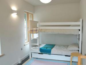 ein weißes Etagenbett in einem Zimmer mit Fenster in der Unterkunft Love Barn in Darlington