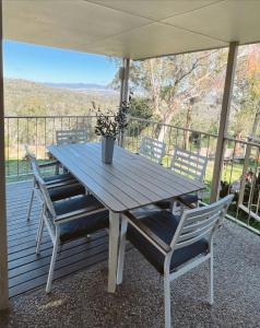 una mesa de madera y sillas en una terraza en Ballandean Views, Ballandean Queensland, en Ballandean