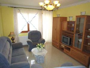 uma sala de estar com um sofá e uma televisão em Nádas Társasház em Balatonlelle