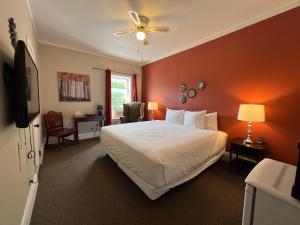 um quarto com uma cama branca e uma parede vermelha em Inn at the Falls em Bracebridge