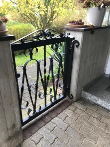 Una puerta de hierro negro con un jardín detrás. en Gemütliches Gästehaus!, en Waldkraiburg