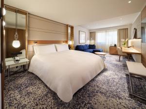 a hotel room with a large bed and a living room at InterContinental Barcelona by IHG in Barcelona