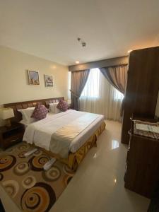 a bedroom with a large bed and a large rug at Burj Alawal in Al Jubail