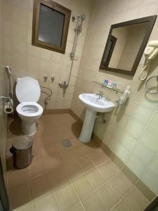 a bathroom with a toilet and a sink at Burj Alawal in Al Jubail