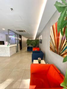 an office lobby with orange and blue furniture and plants at Swing & Pillows - KL Cheras Maluri in Kuala Lumpur