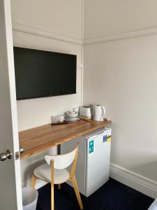 a room with a desk and a chair and a television at Seven Seas Hotel in Carrington