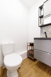 a bathroom with a white toilet and a sink at M Suites - Gaillac Centre in Gaillac