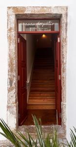 Un escalier mène à un bâtiment avec une porte rouge. dans l'établissement Casa do Postal @ Casas do Pátio (5), à Coimbra