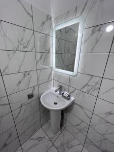 a white bathroom with a sink and a mirror at Zolotoy Fazan in Mykolaiv