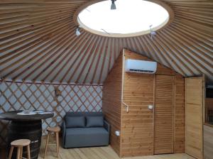 um quarto numa tenda com uma cadeira e uma mesa em Jurtafarm Ráckeve - a nomád luxus em Ráckeve