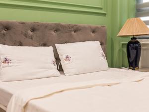 1 cama con 2 almohadas y una lámpara en una mesa en Madelise Max Hotel, en Hanói