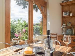 una mesa con una botella de vino y una ventana en The Garden Retreat, en Marbury