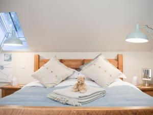 un osito de peluche sentado en una manta en una cama en The Garden Retreat, en Marbury