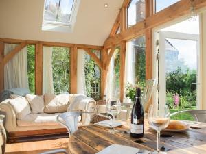 a living room with a couch and a table with wine glasses at The Garden Retreat in Marbury