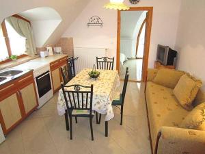 uma cozinha e sala de estar com uma mesa e um sofá em Nádas Társasház em Balatonlelle