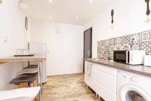 una cucina con forno a microonde, lavatrice e asciugatrice di M Suites - Gaillac Centre a Gaillac