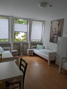 a living room with a bed and two windows at PM-Rooms in Munich