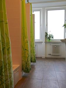 Cette chambre dispose de rideaux jaunes et verts et de deux fenêtres. dans l'établissement PM-Rooms, à Munich