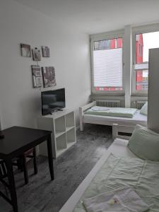 ein Wohnzimmer mit einem Sofa und einem TV in der Unterkunft PM-Rooms in München
