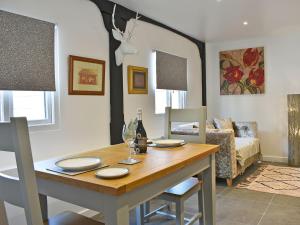 uma sala de jantar com uma mesa e um sofá em The Coach House em Peldon