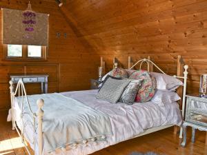 a bedroom with a bed in a log cabin at The Coach House in Peldon