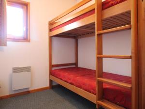 um quarto com 2 beliches e lençóis vermelhos em Appartement Lanslevillard, 3 pièces, 6 personnes - FR-1-508-12 em Lanslevillard