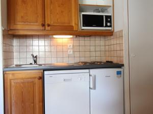 cocina con nevera blanca y microondas en Appartement Lanslevillard, 3 pièces, 6 personnes - FR-1-508-12, en Lanslevillard