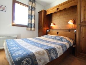 een slaapkamer met een bed met een houten muur bij Appartement Aussois, 3 pièces, 6 personnes - FR-1-508-30 in Aussois