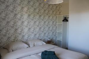フォントネー・ル・コントにあるGîte Rose, Séjour détente et bien être en famille avec jacuzziの花柄の壁紙が貼られたベッドのある寝室
