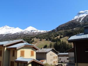 a group of buildings with snow capped mountains in the background at Charmant appartement à 300m des pistes à Lanslebourg avec balcon et garage - FR-1-508-71 in Lanslebourg-Mont-Cenis