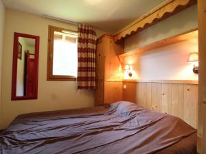 a bedroom with a bed and a window in it at Appartement Lanslebourg-Mont-Cenis, 3 pièces, 6 personnes - FR-1-508-121 in Lanslebourg-Mont-Cenis
