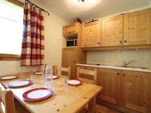 a kitchen with a wooden table with red and white plates on it at Appartement Lanslebourg-Mont-Cenis, 3 pièces, 6 personnes - FR-1-508-121 in Lanslebourg-Mont-Cenis