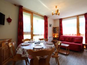 sala de estar con mesa y sofá rojo en Appartement Lanslevillard, 2 pièces, 4 personnes - FR-1-508-123, en Lanslevillard