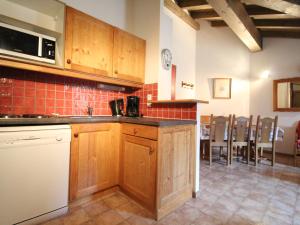 a kitchen with wooden cabinets and a table and chairs at Appartement Lanslevillard, 3 pièces, 6 personnes - FR-1-508-129 in Lanslevillard