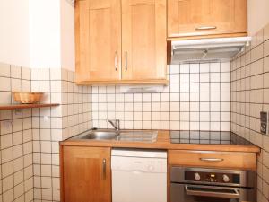 a small kitchen with wooden cabinets and a sink at Appartement Lanslebourg-Mont-Cenis, 3 pièces, 7 personnes - FR-1-508-98 in Lanslebourg-Mont-Cenis