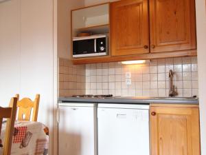 a kitchen with a refrigerator and a microwave at Appartement Lanslevillard, 3 pièces, 6 personnes - FR-1-508-81 in Lanslevillard