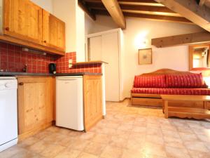 a kitchen with a red couch in a room at Appartement Lanslevillard, 2 pièces, 4 personnes - FR-1-508-145 in Lanslevillard