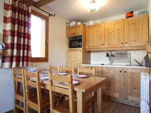 a kitchen with a wooden dining room table and chairs at Appartement Lanslebourg-Mont-Cenis, 3 pièces, 6 personnes - FR-1-508-105 in Lanslebourg-Mont-Cenis