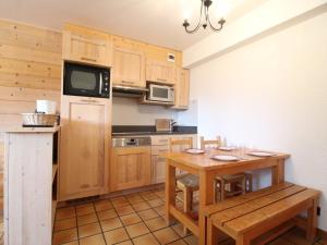 een keuken met een houten tafel en een kleine tafel en stoelen bij Appartement Lanslevillard, 2 pièces, 5 personnes - FR-1-508-131 in Lanslevillard