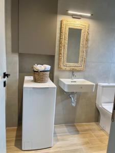 a bathroom with a sink and a basket on a counter at Campana’s Apartment in Argostoli