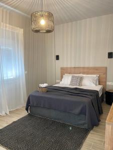 a bedroom with a large bed and a chandelier at Campana’s Apartment in Argostoli