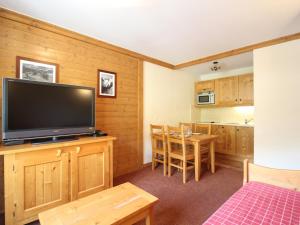 a living room with a flat screen tv and a kitchen at Appartement Lanslebourg-Mont-Cenis, 2 pièces, 4 personnes - FR-1-508-181 in Lanslebourg-Mont-Cenis