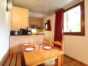 a kitchen with a wooden table with red plates on it at Appartement Lanslevillard, 2 pièces, 5 personnes - FR-1-508-144 in Lanslevillard