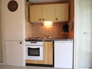 a kitchen with a white stove and a sink at Appartement Lanslevillard, 2 pièces, 4 personnes - FR-1-508-209 in Lanslevillard